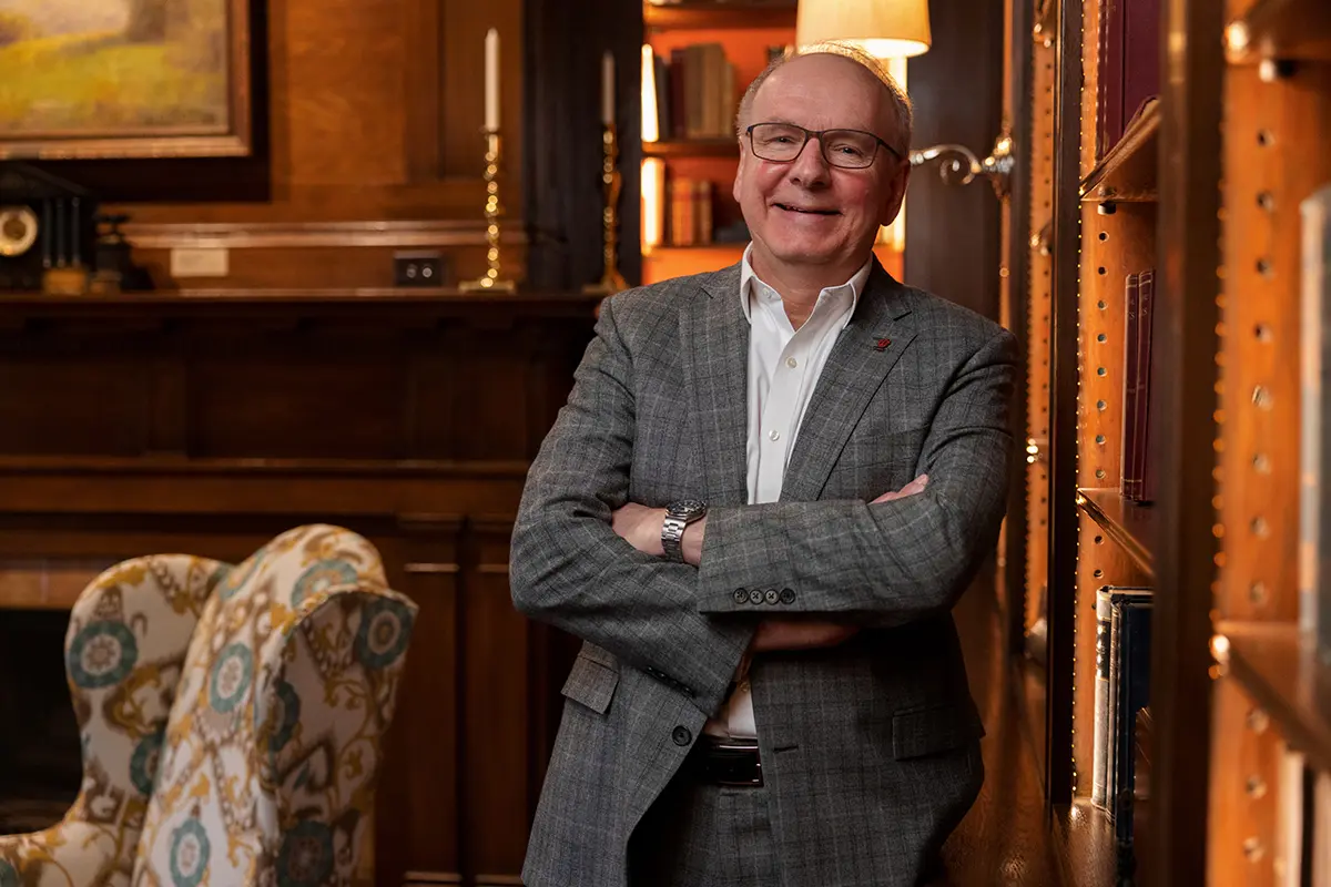 Dean Hess with his arms crossed in a home library
