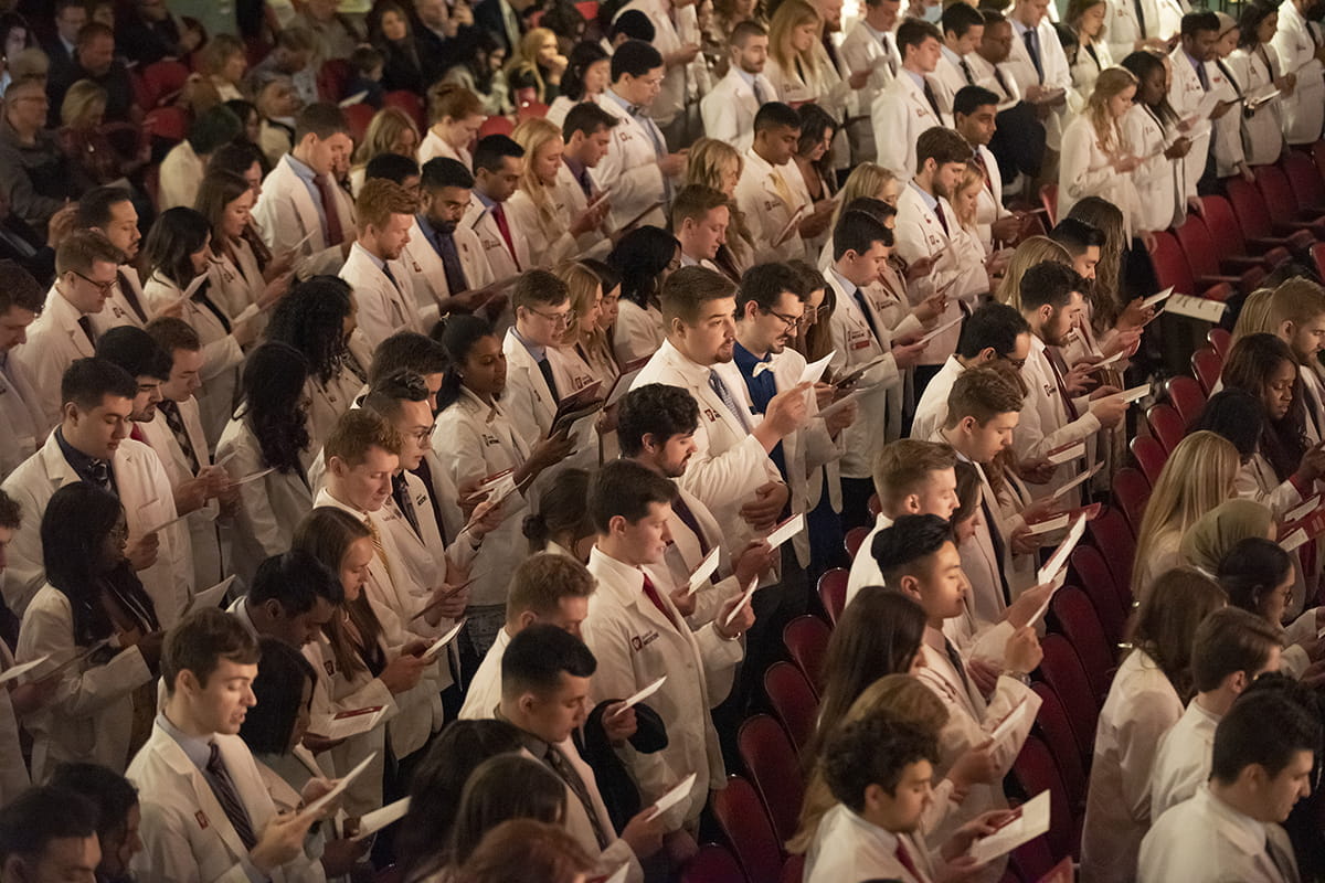 IU School of Medicine students participate in a white coat ceremony before starting their clinical years. Medical Students in an auditorium