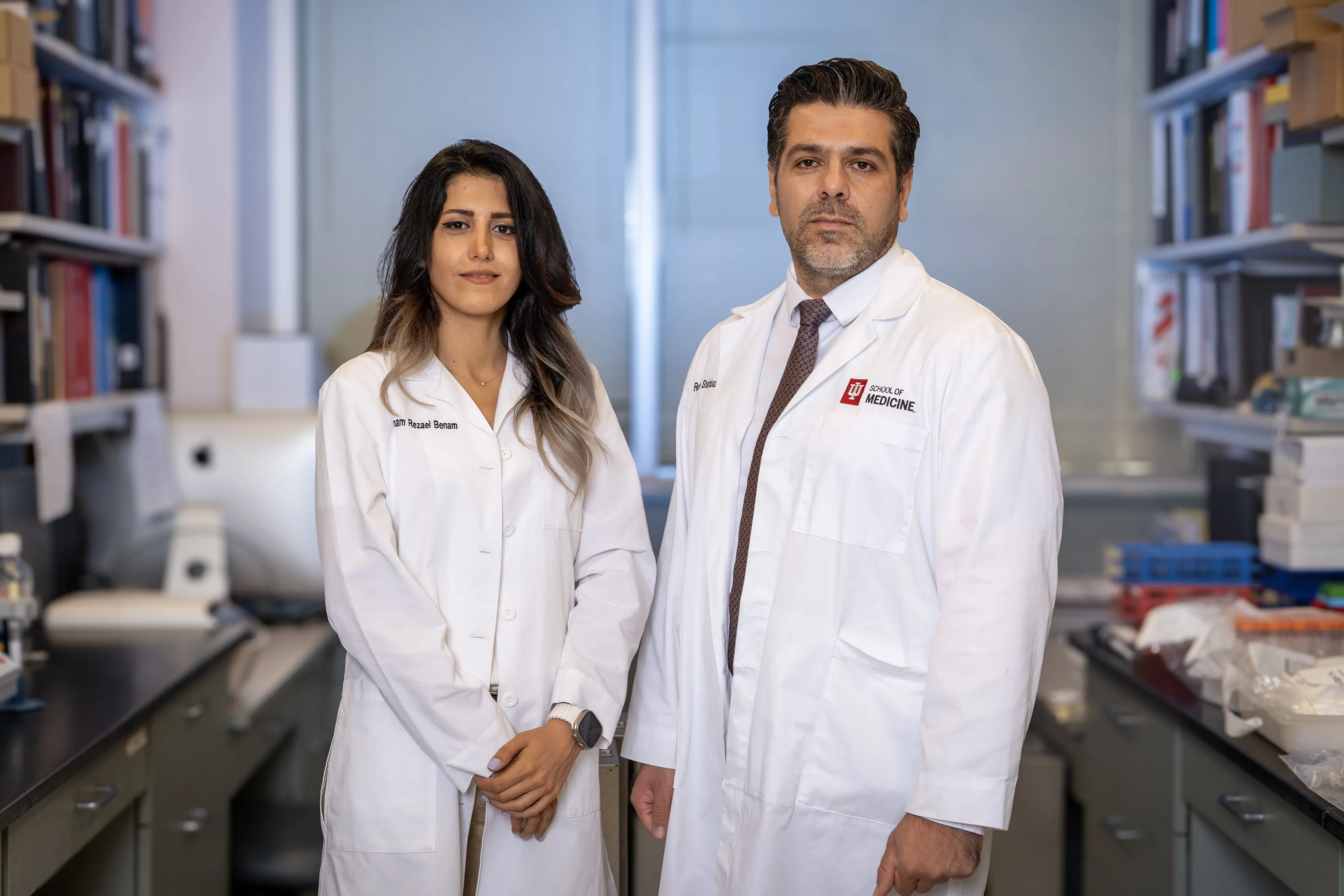 Reza Shahbazi, PhD, stands with Rezaei Benam in a lab wearing white lab coats.