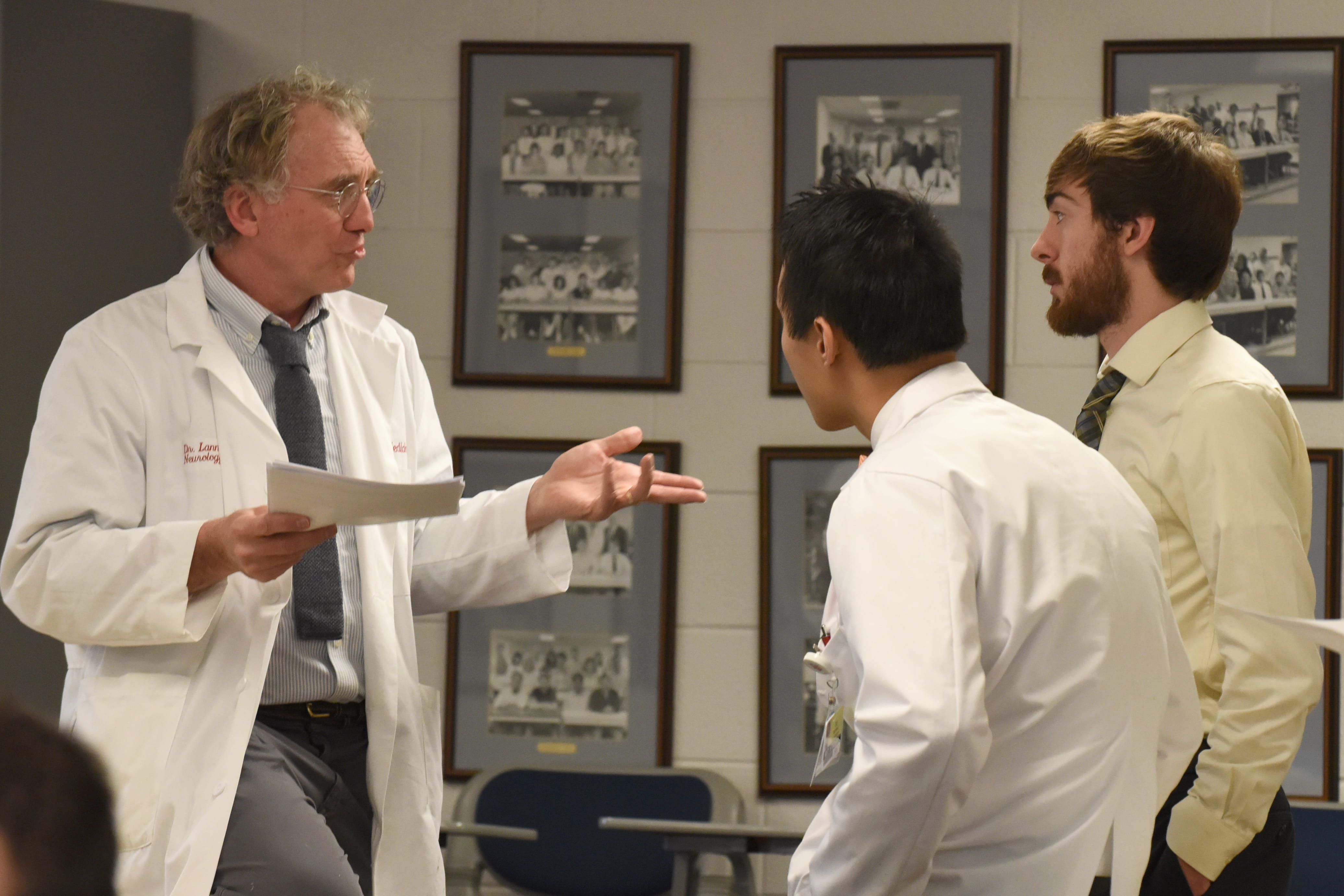 A faculty member talks to two medical students