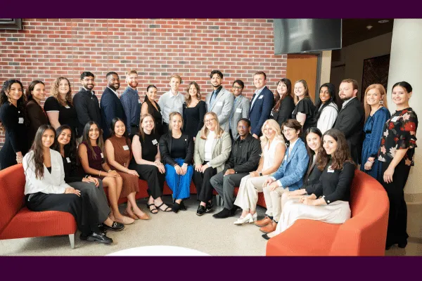 Several students pose for a photo, front row sitting and back row standing.