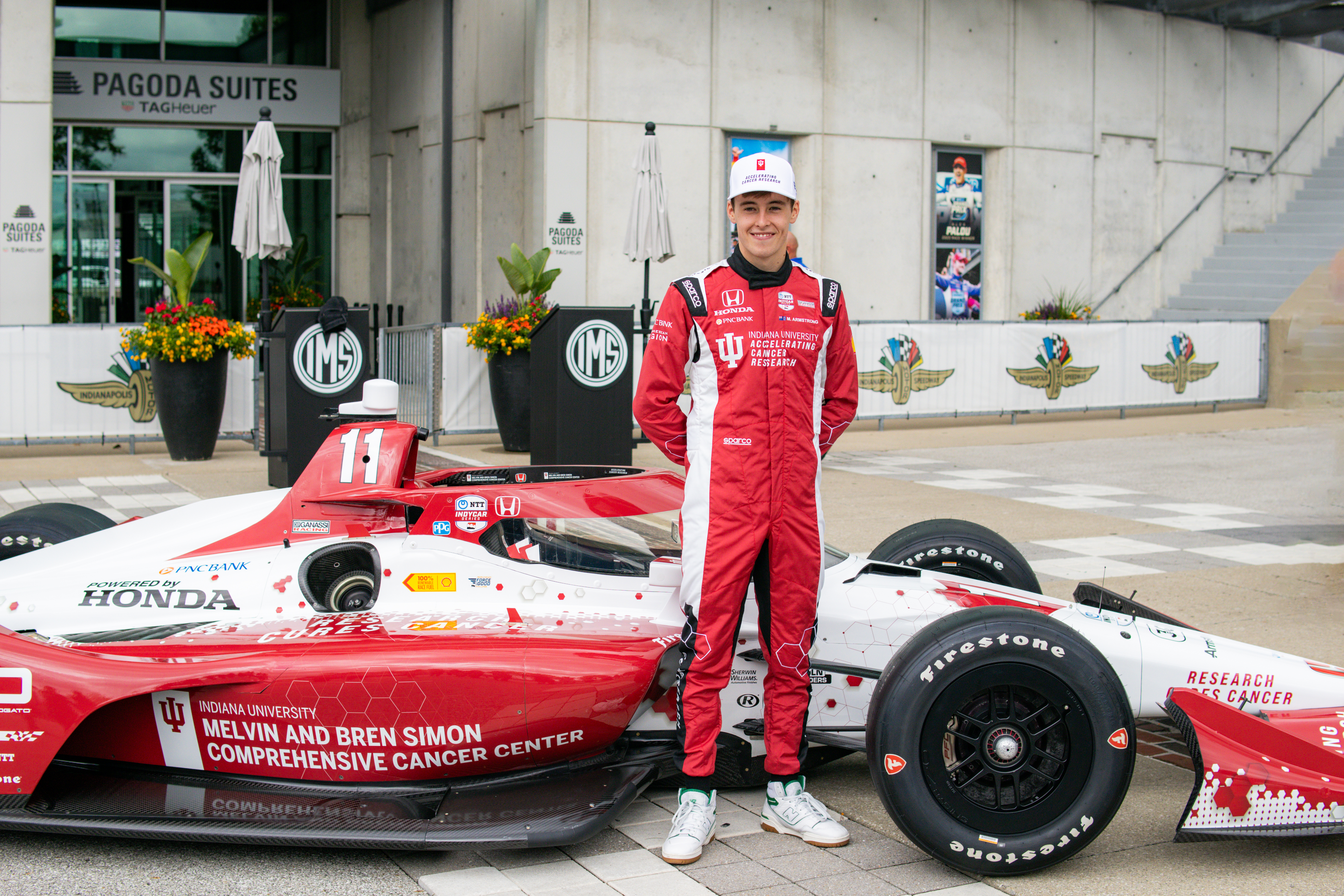 Driver Marcus Armstrong poses with the new No. 11 IU Simon Cancer Center race car.