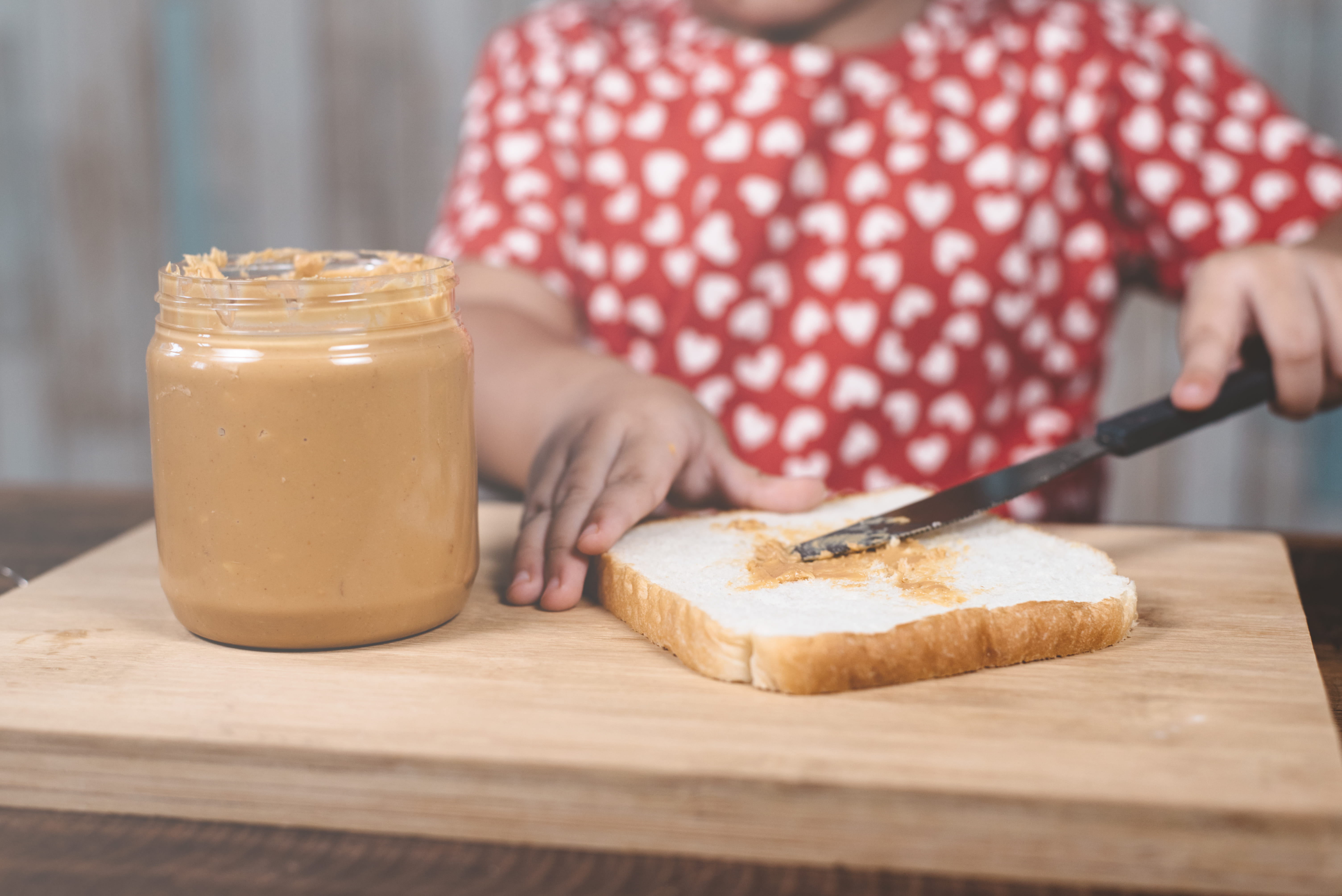 child spreading peanut butter