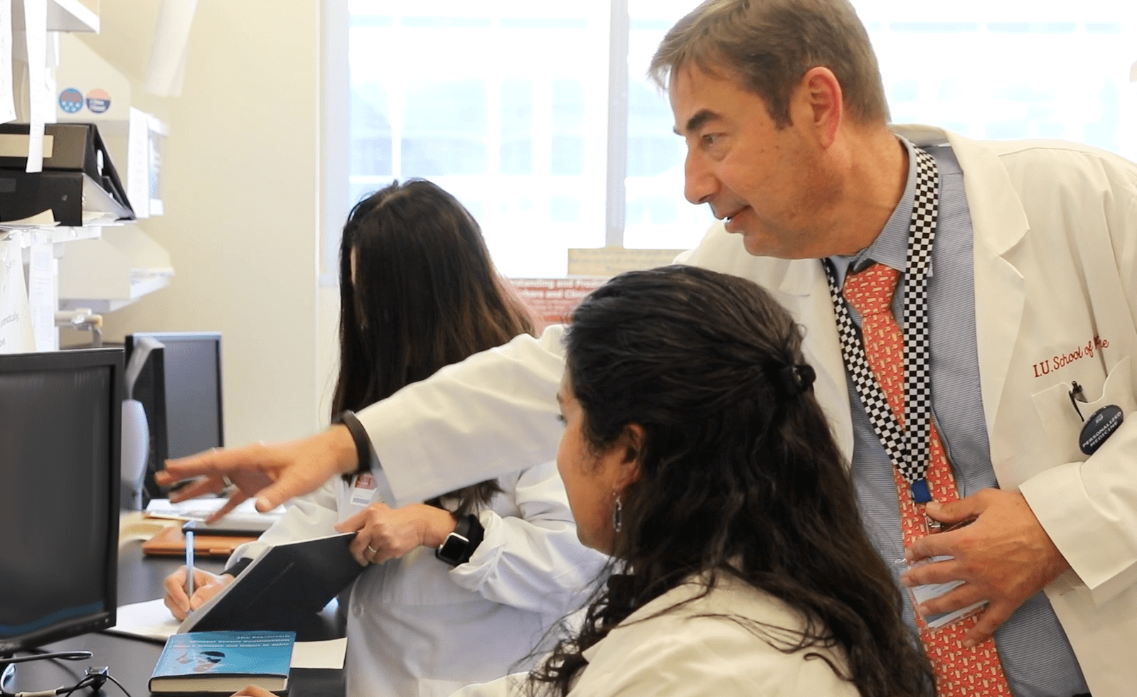 Alexander Niculescu, MD, PhD works with research staff in his laboratory.