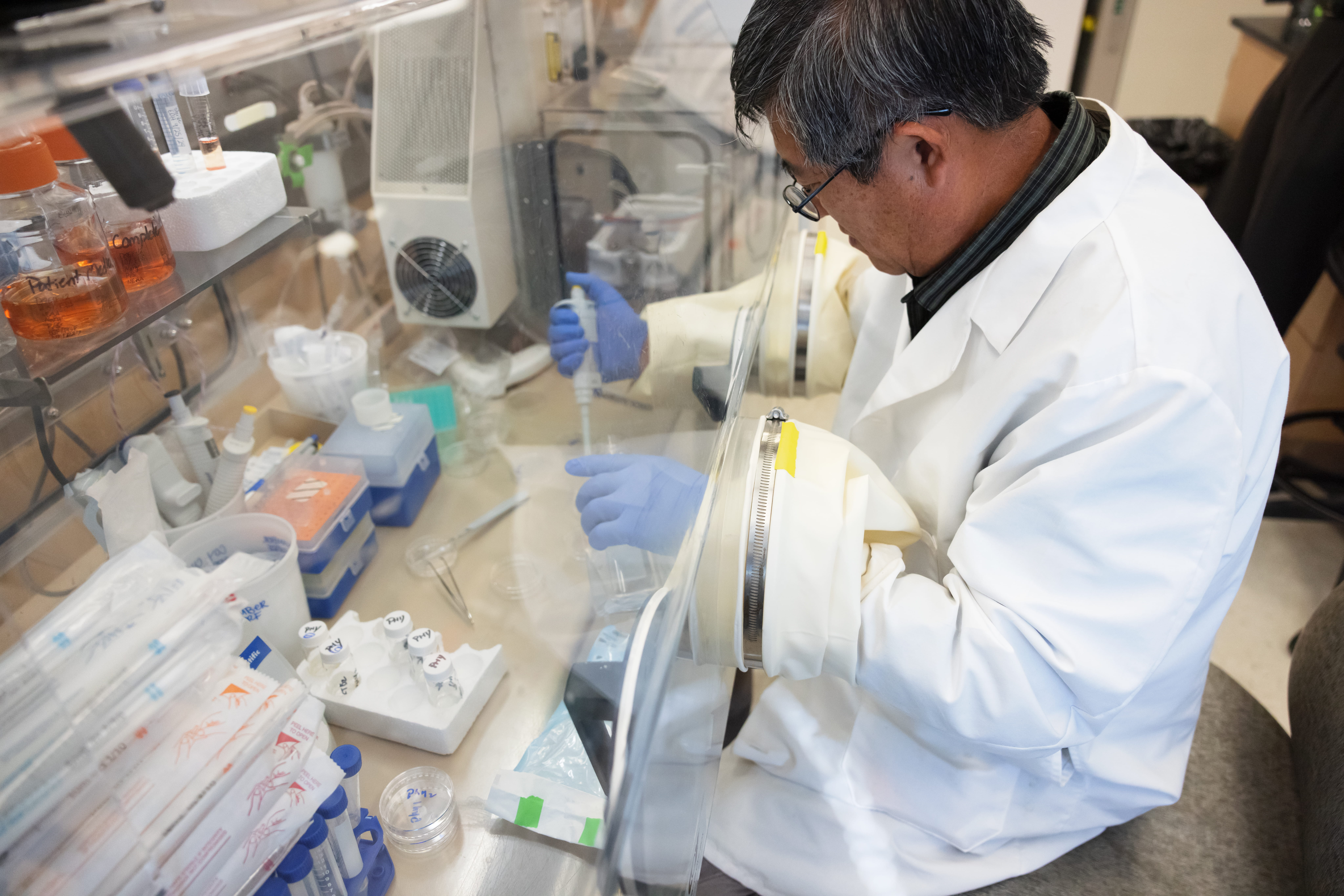 A man collects tissue in a laboratory setting.