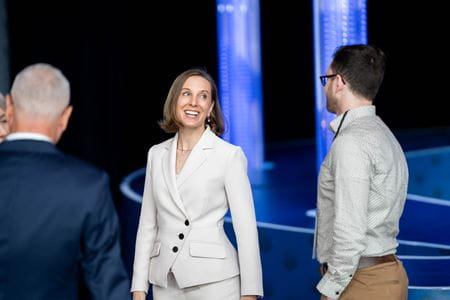 A woman turns as she speaks to a man.