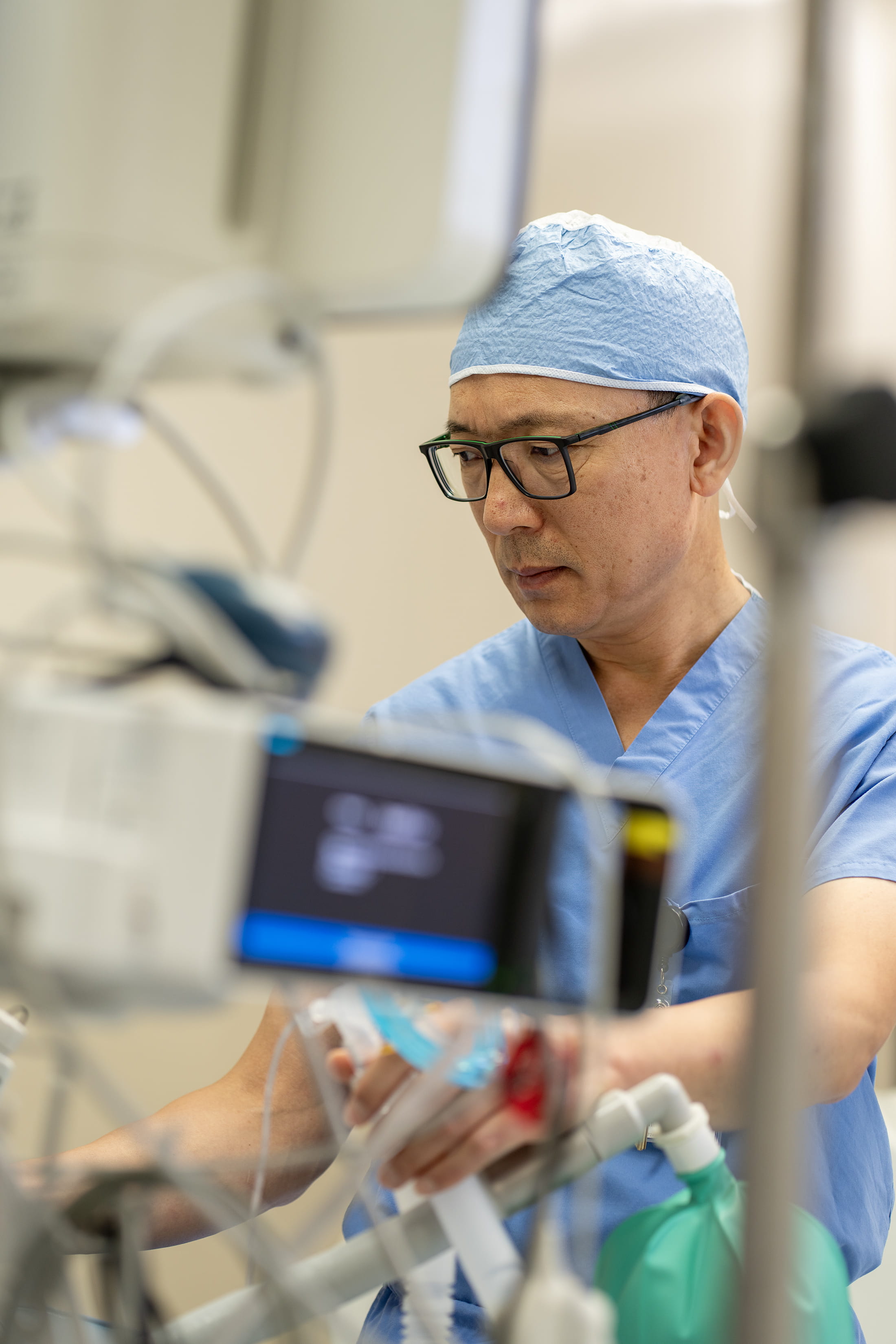 LZ Meng in lab looking at equipment 