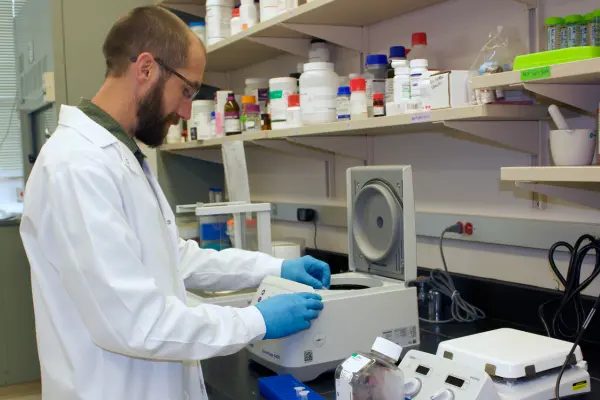 A man in white coat works in a laboratory. 
