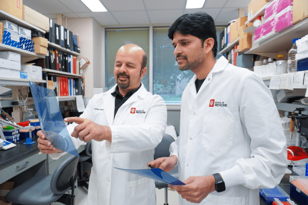 Two men review results in a lab