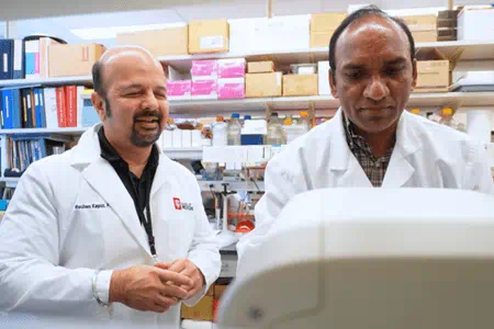 Two men work in a lab