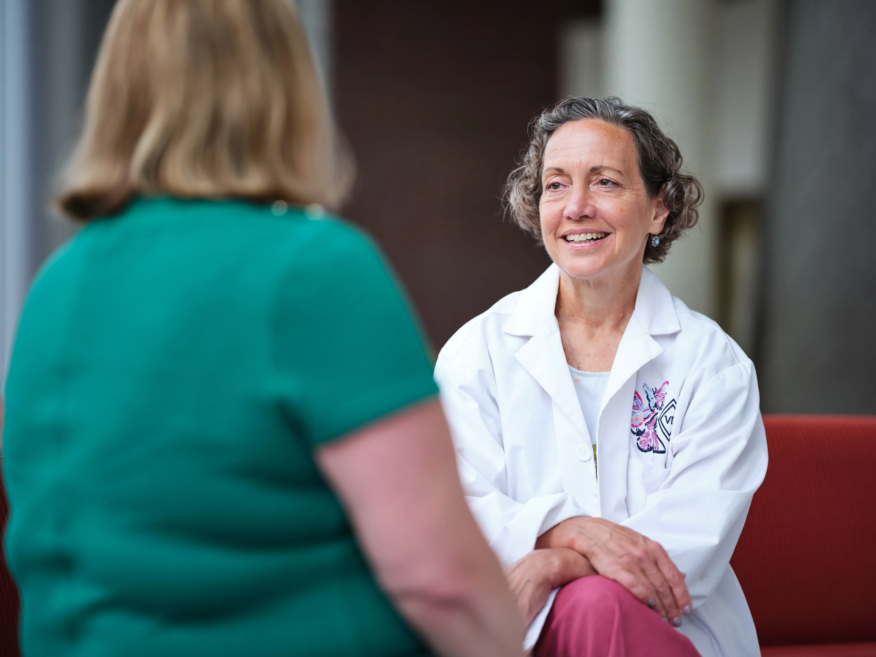 A photo of a physician researcher speaking to a patient. 