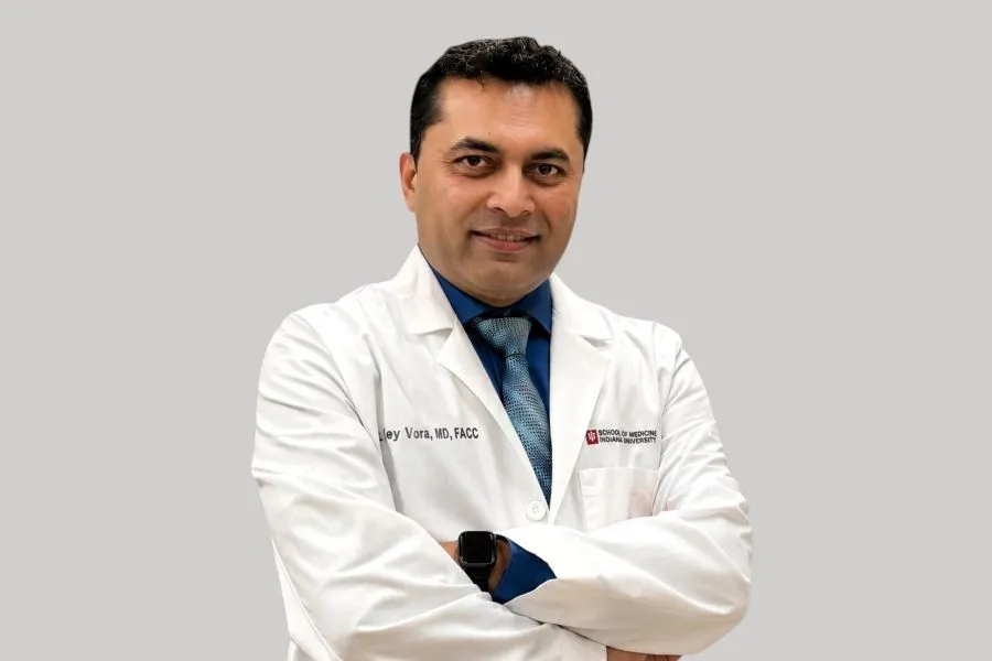 A man in a lab coat poses for a portrait
