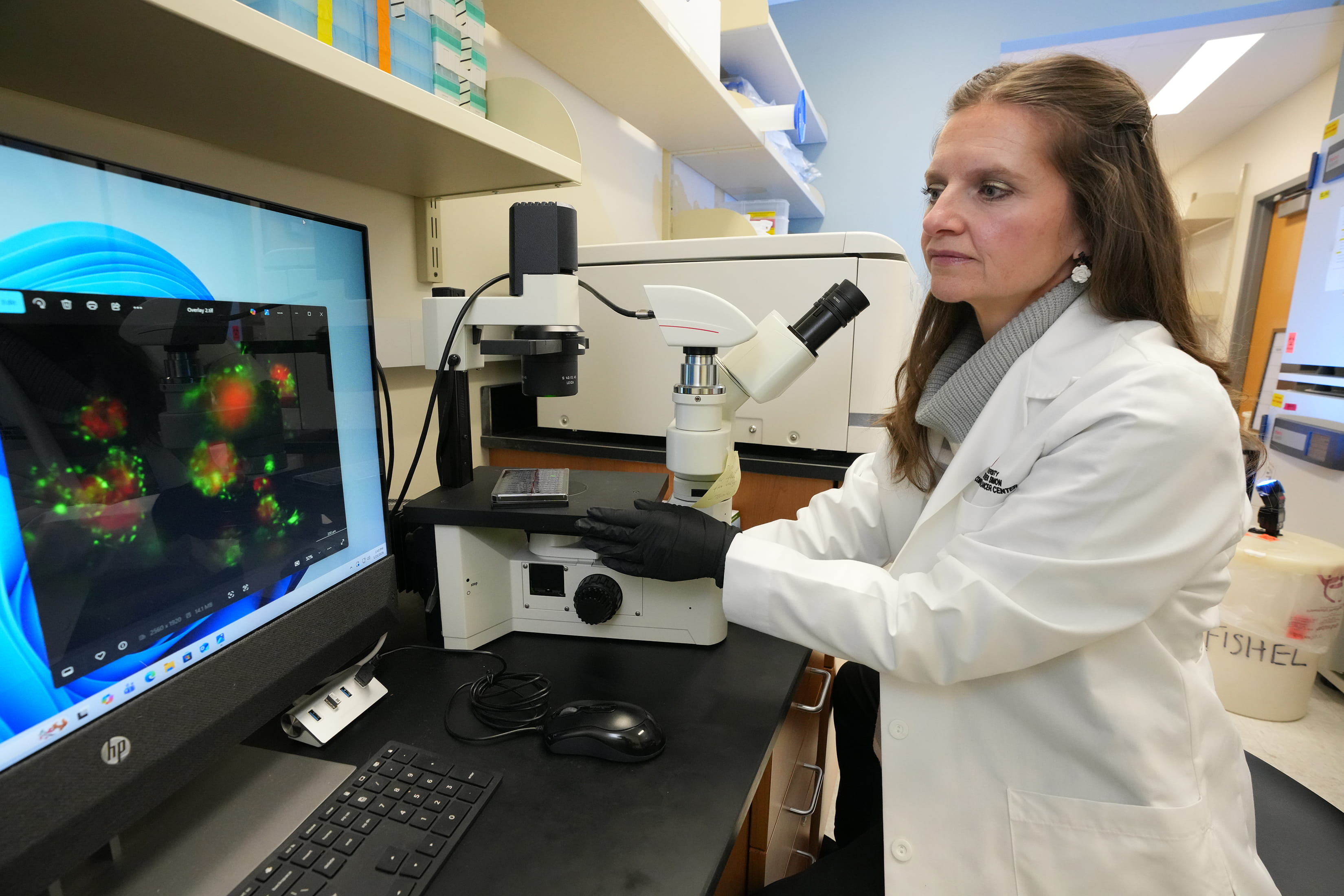 A woman in a white coat works in a lab. 