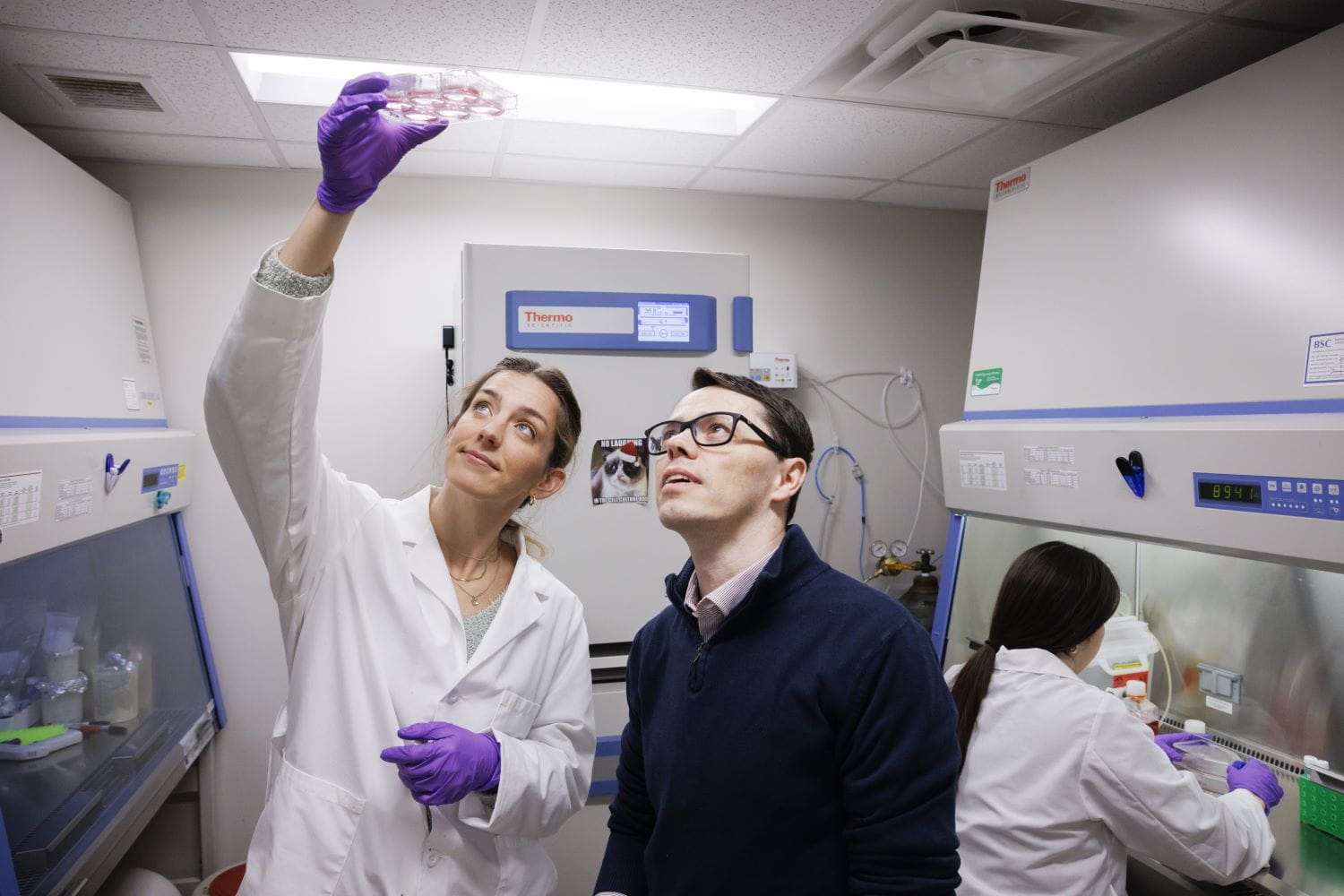 A man and woman look at a lab object