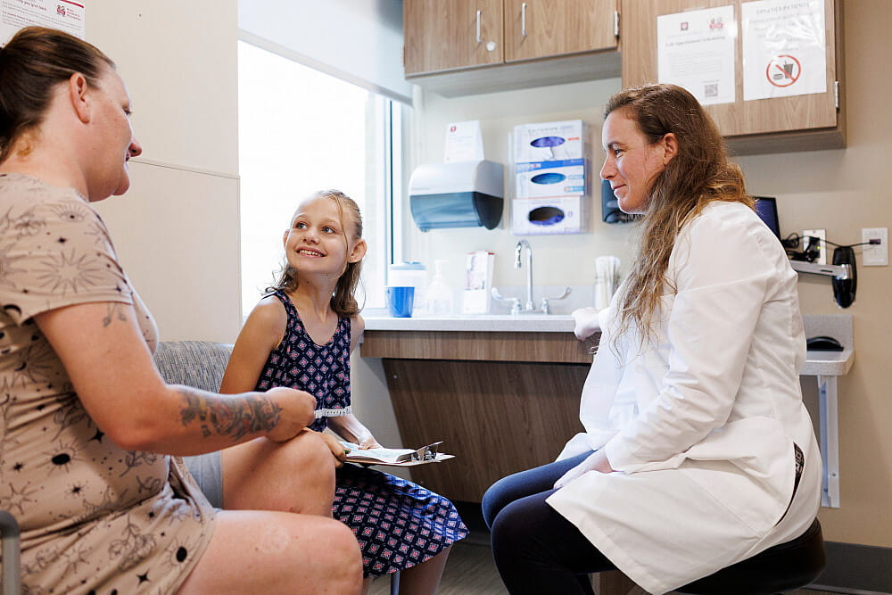 Sarah and her daughter Madison with Doctor in doctors office 