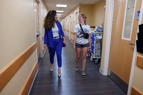 Lessick and oncologist Assi walking down the hallway talking to each other 
