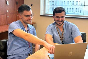 Two physician working together at laptop computer