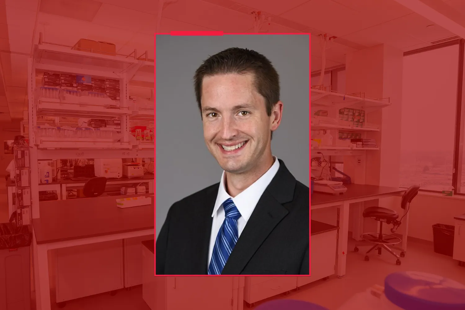 Headshot of Colin Rogerson against a red-tinted background of a research lab.