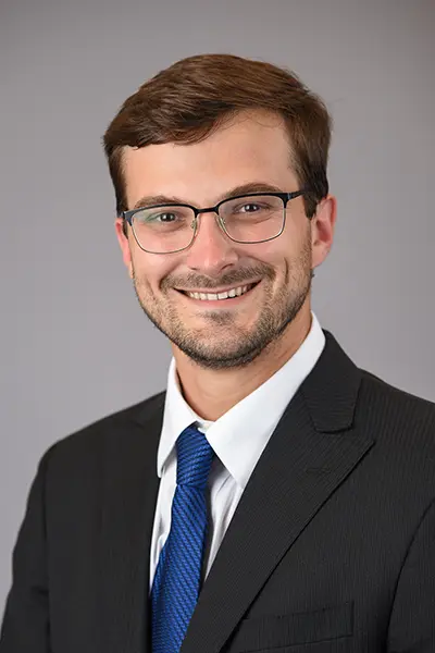 Harrison Thompson, man in suit smiling at camera