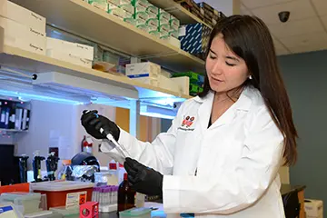 Faculty member works on research in lab.