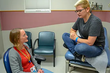 Pediatric patient and physician talk during medical visit.  