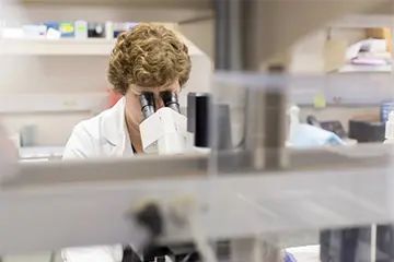 Faculty member using microscope 