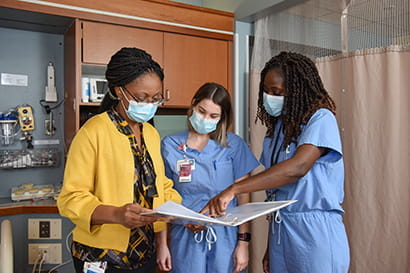 Dr. Chimhanda and two residents review a patient's file together