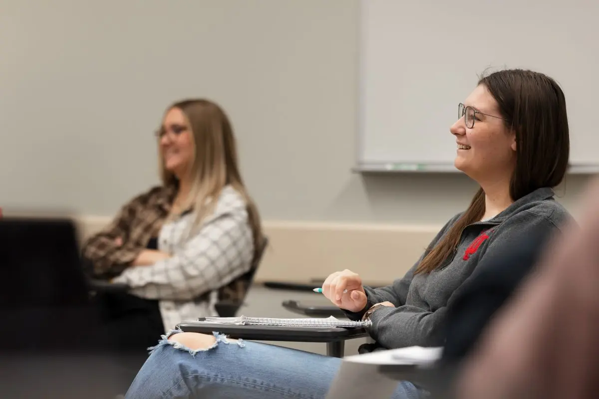 Two students in classroom listen to instruction