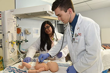 two students work together in the pediatrics sim lab
