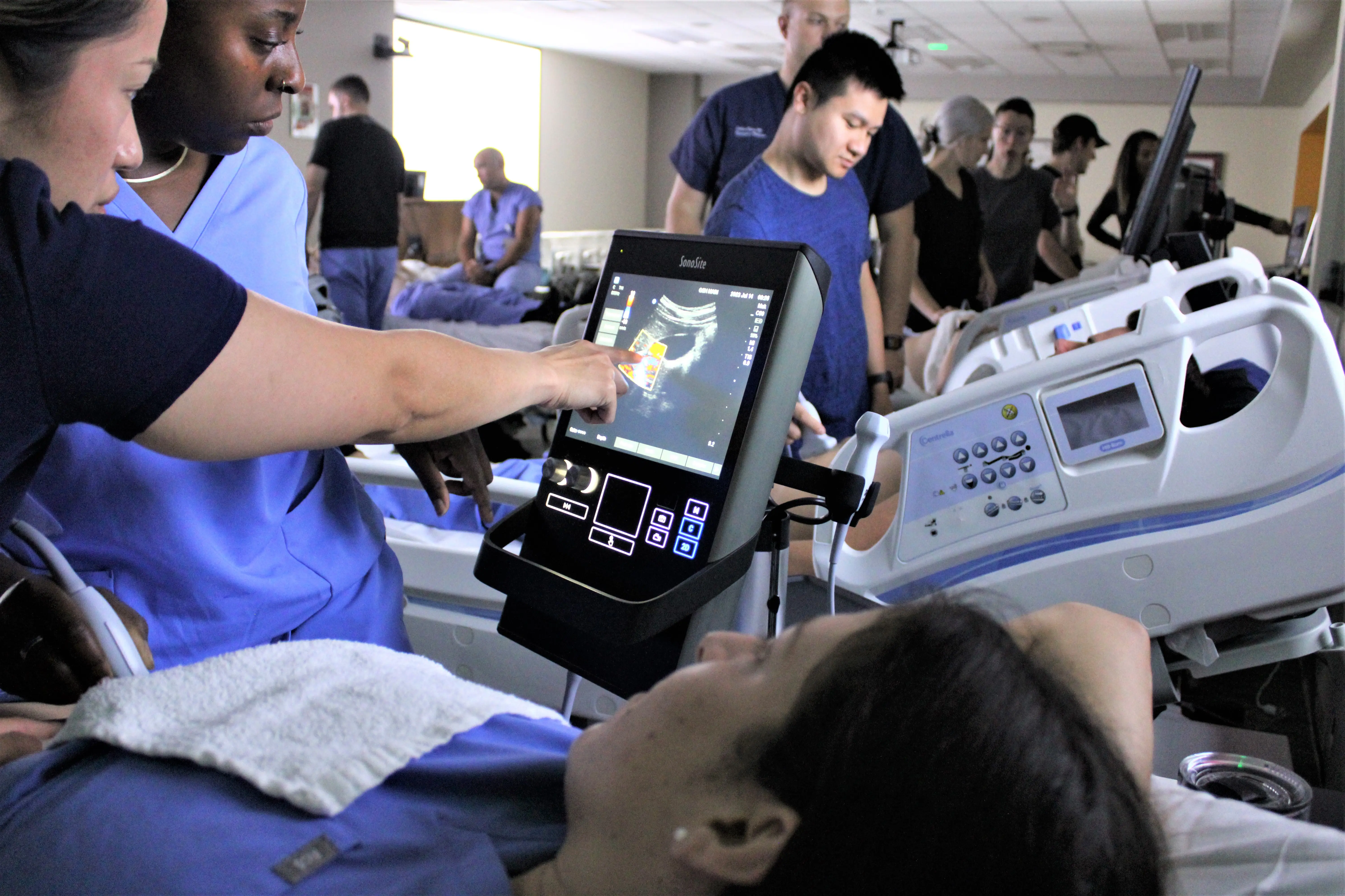 residents look at an ultrasound screen during a training session