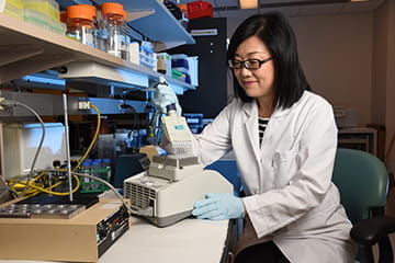 a researcher in a white coat prepares a sample in the lab