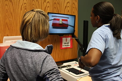two residents practice a surgery simulation