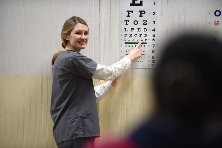 a student reviews a vision chart with a patient