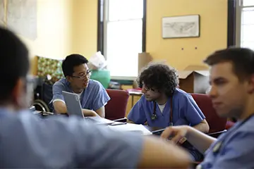 students at a team meeting before the clinic opens