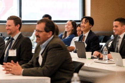 Men and women smiling at professional lecture