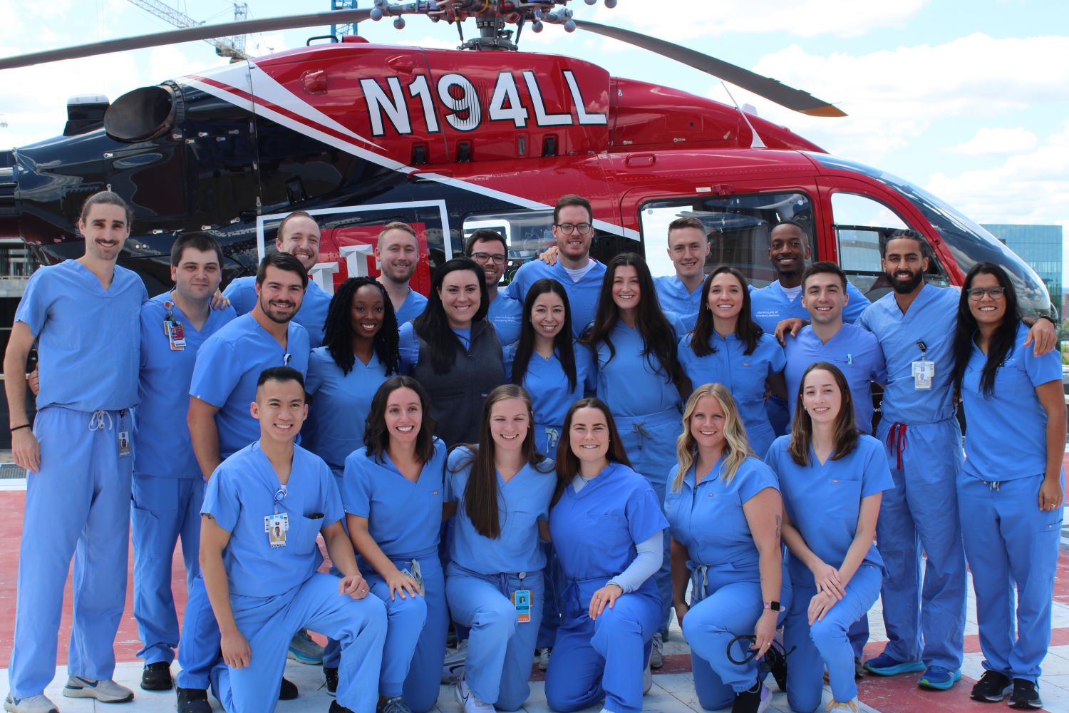 Residents smile in front of a helicopter.