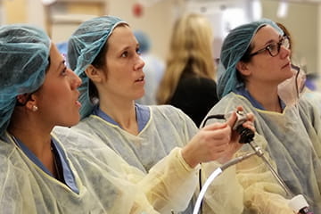 three residents practice surgical skills in the simulation center