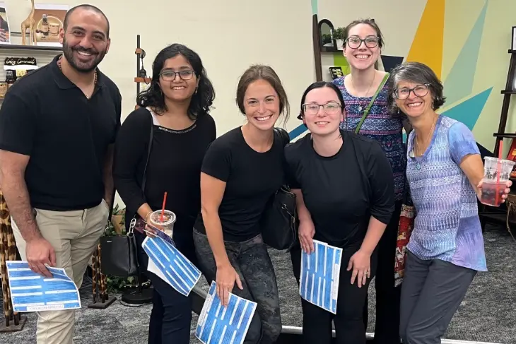 Six residents smile with their arms around each other