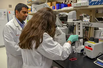 RCF Scholars using a microscope to conduct research