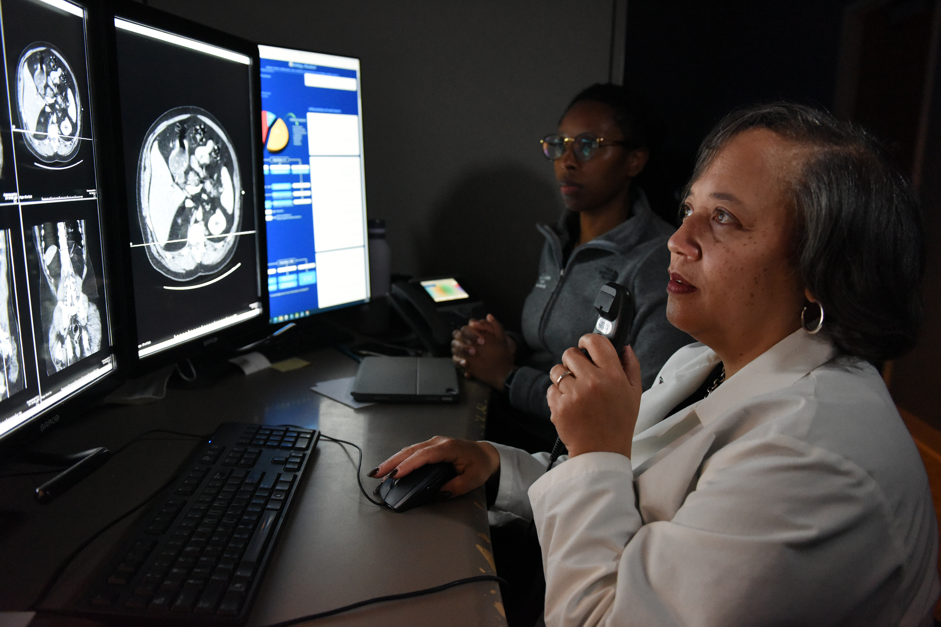 Tina Harris, MD annotates an abdominal scan while a trainee observes.