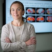 Portrait of Shannon Risacher in front of a monitor with scans on it