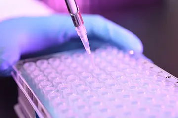a close up shot of a pipette creating lab samples