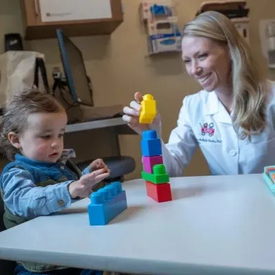 Rebecca McNally Keehn interacting with a young patient playing with blocks
