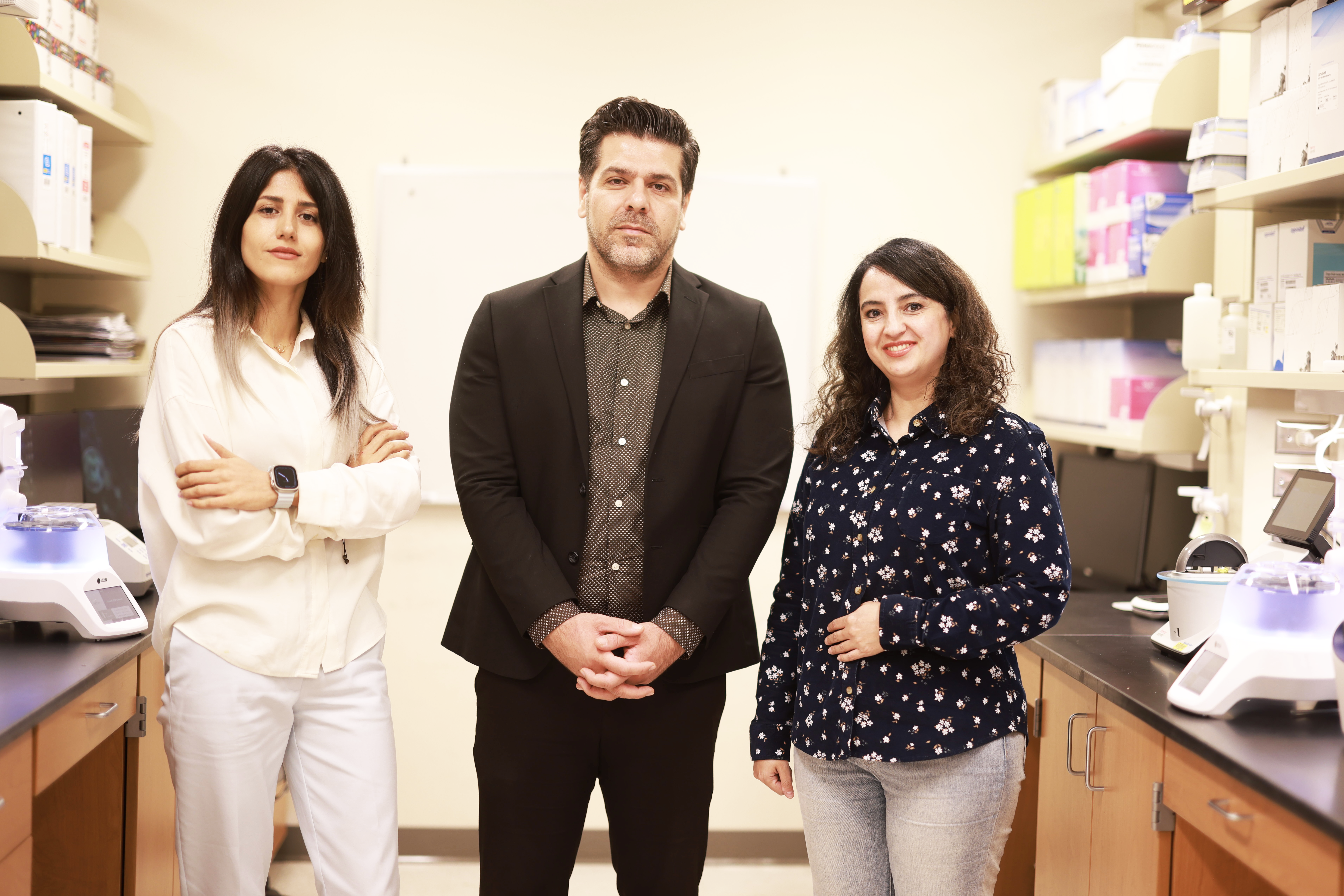 Three researchers stand in a lab space. 