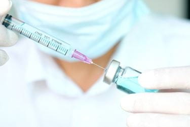 The hand of doctor holding syringe and medicine bottle, preparing an injection.