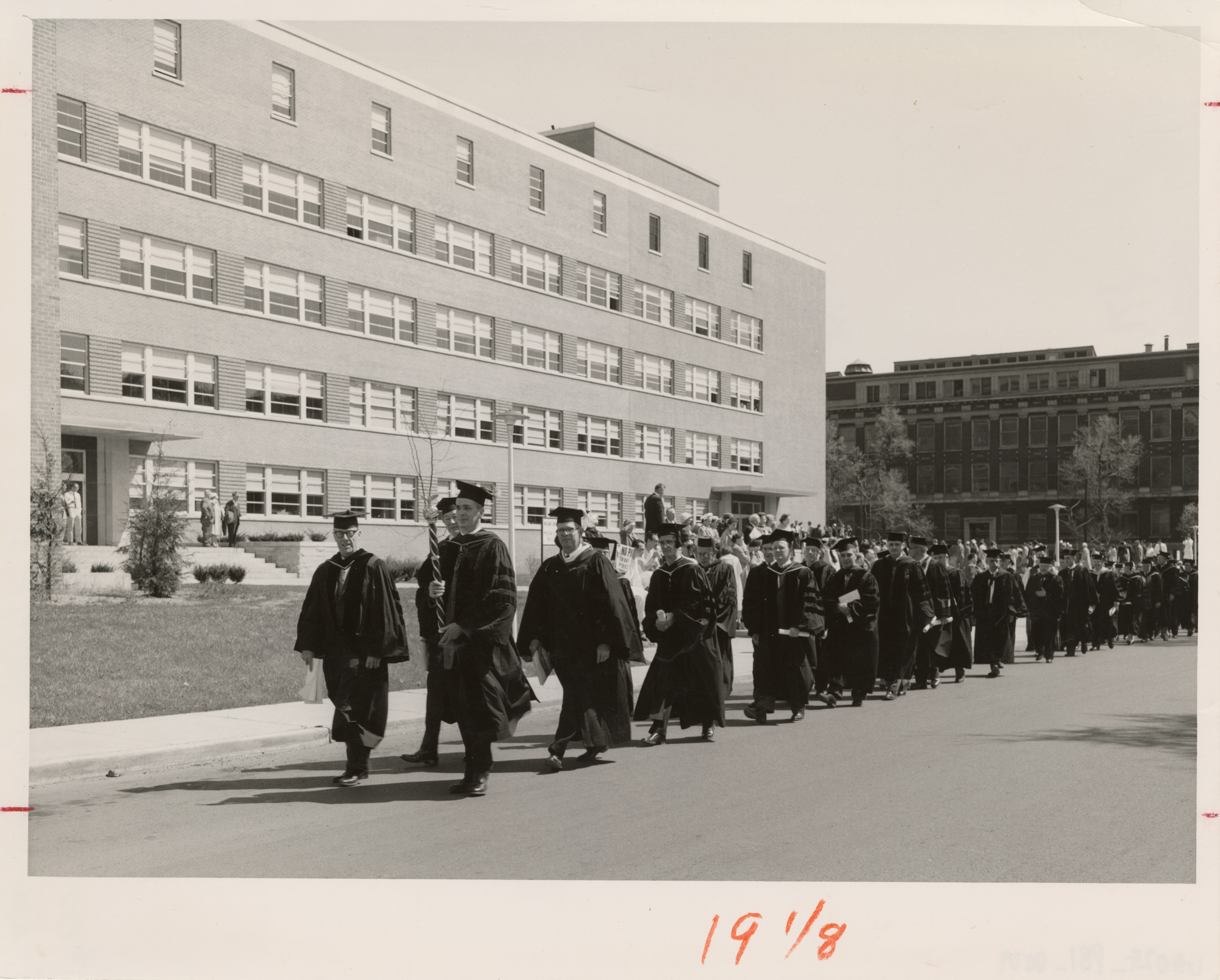 Black and White photo of people walking in front of a building